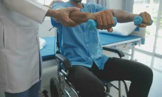 rehabilitering av Inaktiverad människor begrepp. ung fysioterapeut portion senior manlig patient i rullstol övning på Hem. handikappade äldre man Träning med hantlar foto