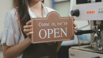 ung asiatisk Start upp små företag ägare öppen de kaffe affär och restaurang. små företag ägare och service sinne. foto