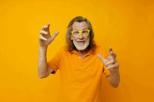porträtt av Lycklig senior man hand gester känslor gul glasögon isolerat bakgrund foto
