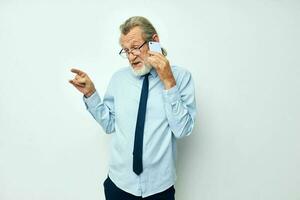 senior gråhårig man i en skjorta med en slips med en telefon teknologi beskurna se foto