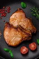 utsökt saftig fläsk eller nötkött biff med salt, kryddor och örter foto