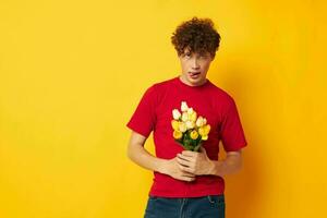 porträtt av en ung lockigt man i en röd t-shirt en bukett av blommor Semester gåva svartvit skott foto