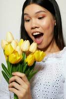charmig ung asiatisk kvinna med en bukett av blommor leende närbild livsstil oförändrad foto