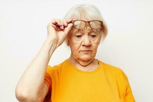 Foto av pensionerad gammal lady i tillfällig t-shirt och glasögon isolerat bakgrund