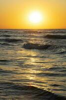 skön solnedgång över de hav. röd Sol och vågor. foto
