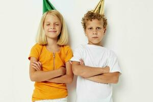 två glad barn Framställ känslor Semester färgrik caps ljus bakgrund foto
