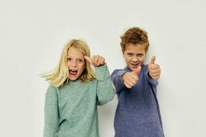 pojke och flicka i flerfärgad tröjor Framställ för roligt livsstil oförändrad foto