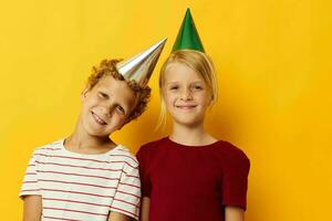 små barn Semester roligt med caps på din huvud gul bakgrund foto