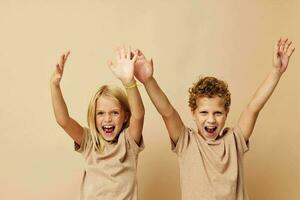 pojke och flicka i beige t-tröjor Framställ för roligt barndom oförändrad foto