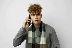 attraktiv man i en pläd scarf ser på de telefon mode livsstil oförändrad foto