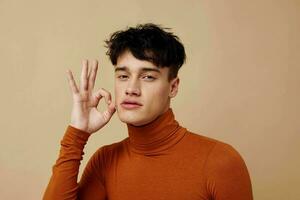 en ung man brun turtleneck Framställ mode ljus bakgrund oförändrad foto