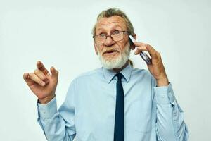 Foto av pensionerad gammal man talande på de telefon företag arbete isolerat bakgrund