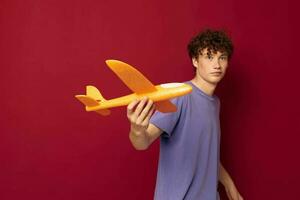 tonåring med leksak flygplan underhållning röd bakgrund oförändrad foto