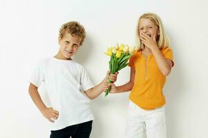 pojke och flicka med en bukett av blommor gåva födelsedag Semester barndom ljus bakgrund foto