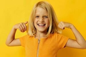 porträtt av en liten flicka i en gul t-shirt leende Framställ studio barndom livsstil oförändrad foto