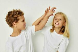 Foto av två barn i vit t-tröjor är stående Nästa till barndom oförändrad