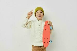 porträtt av Lycklig leende barn flicka eleganta kläder skateboard ljus bakgrund foto