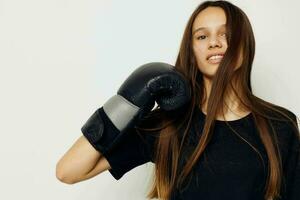 ung skön kvinna i svart sporter enhetlig boxning handskar Framställ isolerat bakgrund foto