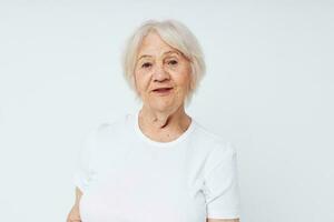 porträtt av leende äldre kvinna vit t-shirt isolerat bakgrund foto
