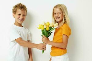 söt förskola barn med en bukett av blommor gåva födelsedag Semester barndom ljus bakgrund foto