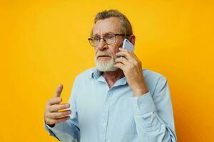 porträtt äldre man grå skägg med glasögon talande på de telefon oförändrad foto