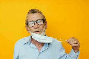 Foto av pensionerad gammal man i medicinsk mask skydd isolerat bakgrund