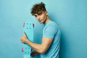 stilig kille skateboard i hand i blå t-tröjor livsstil oförändrad foto