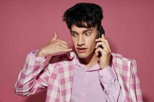 stilig kille med en telefon i hand rosa blazer mode elegant stil livsstil oförändrad foto