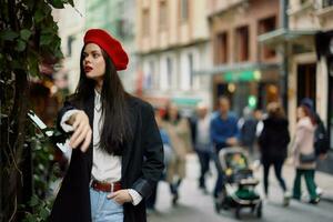 kvinna mode modell promenader på de gata i de stad Centrum bland de folkmassan i en jacka och röd basker och jeans, filmiska franska mode stil Kläder, resa till istanbul foto