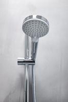 duschhuvud på en grå mikrocementvägg i ett modernt badrum foto