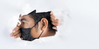 närbild porträtt av mannen bär skyddande ansiktsmask mot coronavirus foto