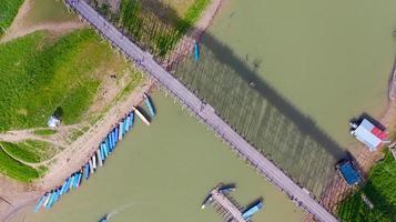 Flygfoto ovanifrån av träbro med turnébåt i Thailand foto