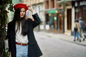 flicka leende med tänder står på de gata i de stad i en jacka och röd basker, filmiska franska mode stil Kläder, resa till istanbul foto