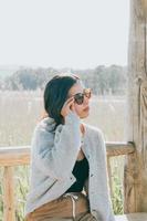 kvinna som använder solglasögon som ler mot kameran när hon är på gården