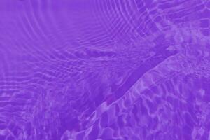 lila vatten med krusningar på de yta. defokusering suddig transparent rosa färgad klar lugna vatten yta textur med stänk och bubblor. vatten vågor med lysande mönster textur bakgrund. foto