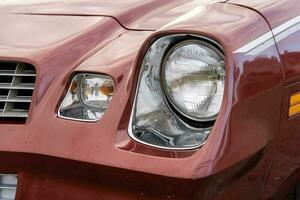 främre strålkastare är en närbild av ett gammal kraftfull klassisk amerikan bil foto