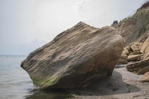 stora stenblock ligger på stranden foto