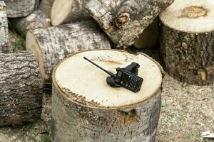de walkie talkie är liggande på en trä- stubbe. betyder av kommunikation foto