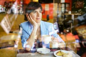 trånande lady dricka kaffe i cafeteria foto