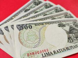 stänga upp se av gammal indonesiska sedlar rp.500,00 utfärdad i 1992. rupiah valuta begrepp isolerat på en röd bakgrund. selektiv fokus foto