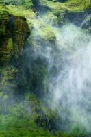 mysterium vattenfall strömmande med dimmig i frodig kanjon foto