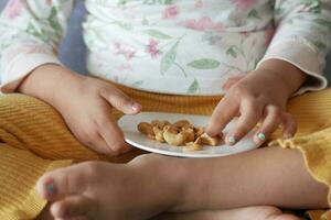 barn äter kasju nötter på tabell foto