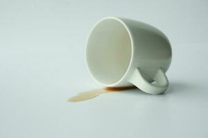 kopp av kaffe spillts på vit bakgrund foto