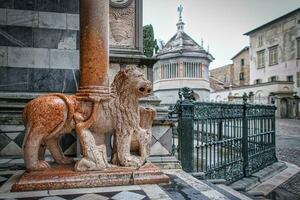 på de ingång till de basilika av santa maria maggiore i bergamo dörr av röd lejon foto