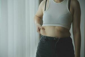 fett kvinna, fett mage, knubbig, fet kvinna hand innehav överdriven mage fett med mäta tejp, kvinna diet livsstil begrepp foto