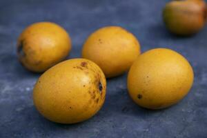 stänga upp av man hand innehav färsk mango frukt i natur bakgrund foto