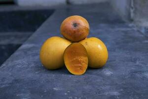 mogen gul mango frukt på en svart bakgrund. tropisk frukt. foto