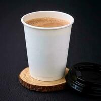 kaffe i en papper kopp på en trä- stå på en svart bakgrund foto