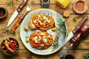schnitzel med oliver och tomat foto