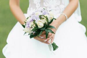 de brudens bröllop bukett av mjölk ro och lila eustoms i de händer av de brud foto